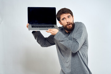 A man in a gray sweater with a laptop hands lifestyle technology communication internet work