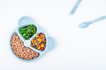 Nutritional meal for children on a plate on white background