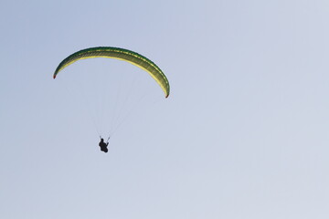 Adventure sports. Person practicing paragliding on the cliffs of the coast. Black and white photo.
