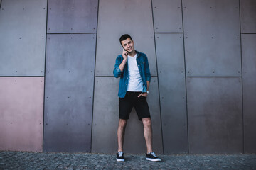 Fototapeta premium Positive young man speaking by phone