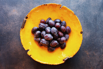 Plums on plate on dark table