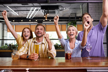 group of friends watching soccer in pub, celebrate the winning, laugh and scream. happy