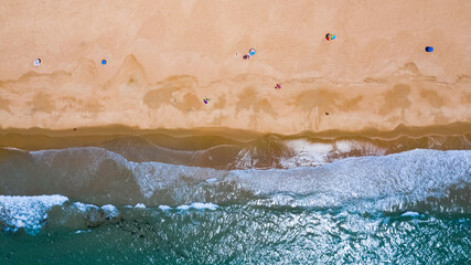 Drone image from above of an Andalusian beach in south Spain with waves breaking on the shore in summer © Pablo