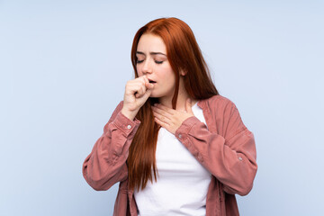 Redhead teenager girl over isolated blue background is suffering with cough and feeling bad