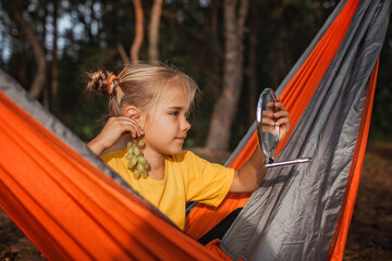 A coquette girl lying in hammock and wearing ripe yellow grape like sweet healthy earrings