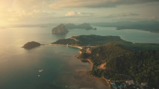 Sunrise at tropical ocean bay islands aerial view. Mountainous islet with exotic plants, forest on ranges at sun rise. Paradise cityscape at Palawan, El Nido, Philippines archipelago, Asia