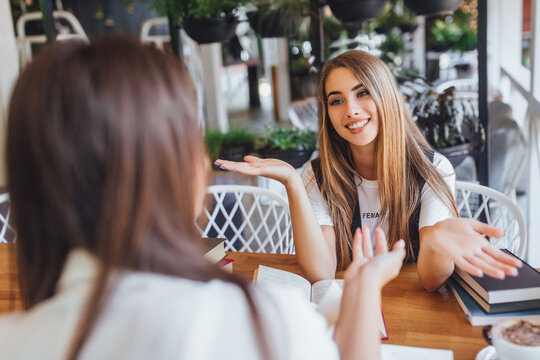 Two Friends Meeting In The Cafe,and Discussing About Work