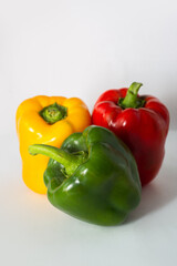 
three multi-colored peppers on a white background