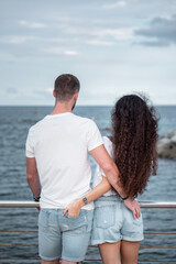 Young couple at the beach being sweet and in love. Boyfriend and girlfriend outdoors photoshoot. Romantic scene of a millennial couple in matching outfits