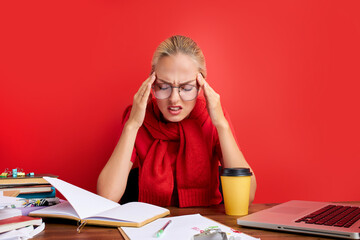 woman has head burst at work, she is suffering from head ache, sit with paper at office desk