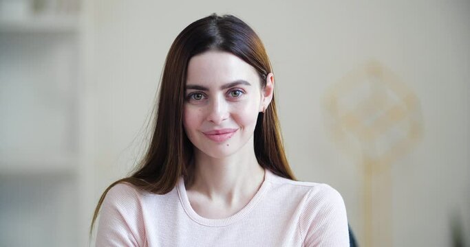 Portrait of beautiful young girl with long hair, millennial women with cute benevolent smiling face, looks at camera calmly confidently, sincere female emotions, concept of innocence purity close up