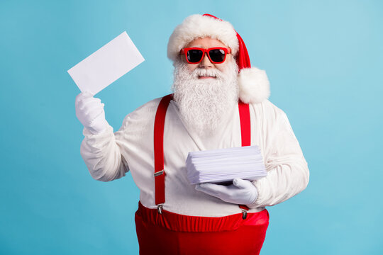 Portrait of his he nice attractive cheerful confident white-haired Santa father holding in hand pile mail letters wish list December Eve Noel isolated bright vivid shine vibrant blue color background