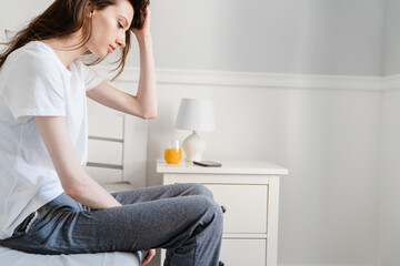 Image of beautiful girl stretching her body while sitting in bed