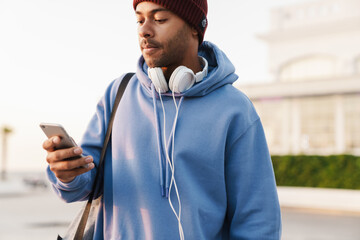 Young african man with phone and headphones