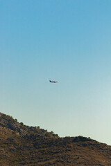 Beautiful minimalistic photo of an airplane in the sky over mountains and lake, desktop wallpaper