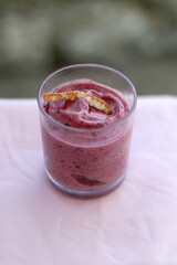 Bowl of banana and berry nice cream, decorated with candied orange peel. Selective focus.