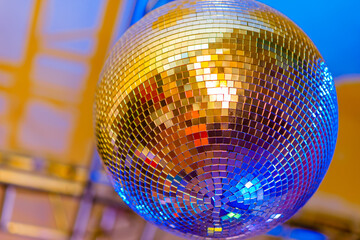 Big disco ball on a colored background in a nightclub