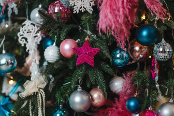 Beautiful blue and pink Christmas tree toys hang on the Christmas tree
