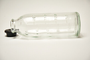 Glass bottle for saline, on a light background.