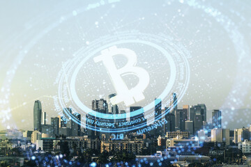 Double exposure of creative Bitcoin symbol hologram on Los Angeles office buildings background. Mining and blockchain concept