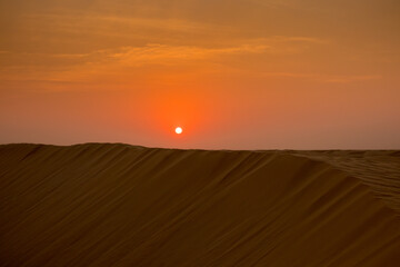 View of windy sand dunes deep in desert of Abu Dhabi - United Arab Emirates. Windy day in desert, desert safari.