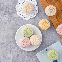 Colorful snow skin moon cake, sweet snowy mooncake, traditional savory dessert for Mid-Autumn Festival on gray cement background, top view