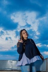 Beautiful young woman on the rooftop in the evening.