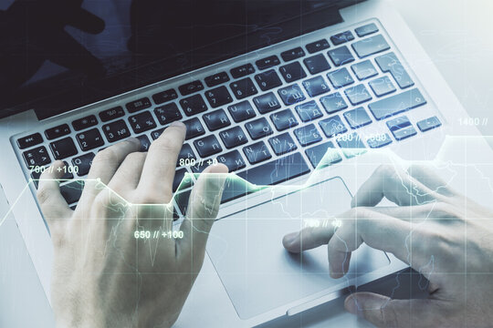 Double exposure of abstract creative statistics data hologram with hands typing on laptop on background, analytics and forecasting concept