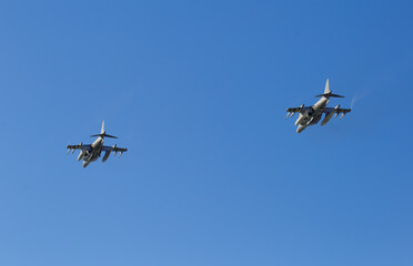 Modern armed military fighter jets flys in formation through the sky.