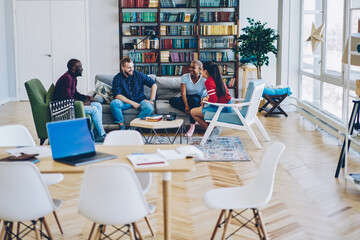 Group of cheerful multiethnic friends talking at home