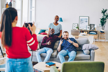 Cheerful diverse friends posing for picture in living room