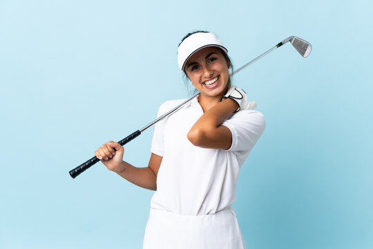 Young hispanic golfer woman over isolated blue wall laughing