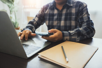 business with  technology concept, business man holding phone and use laptop on working table