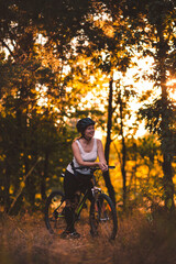 Fototapeta na wymiar The cyclist smiles, traveling and relaxing. Active bike ride in the park at dawn.