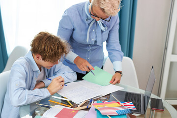 Obraz premium young intelligent teacher explain math or geometry to student, female tutor came at home, enjoy sharing knowledge with boy