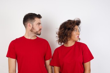 Fototapeta premium Close up side profile photo Young beautiful couple wearing red t-shirt on white background ready to have a walk.