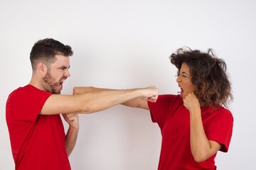 Portrait of strong and determined Young beautiful couple wearing red t-shirt on white background...