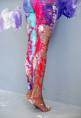beautiful sexy legs and feet on tiptoe of a young artistically abstract painted woman, ballerina with white, blue and purple paint. Creative body art painting, copy space.