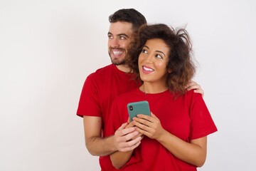 Young beautiful couple wearing red t-shirt on white background holding in hands showing new cell