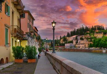 Embankment of Adige river in Verona, Italy. Sunset cityscape of Verona