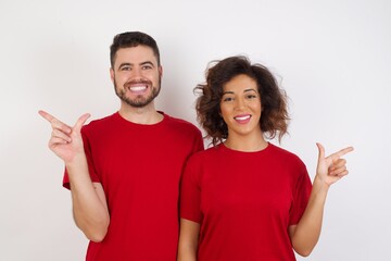 Young beautiful couple wearing red t-shirt on white background pointing up with fingers number eight in Chinese sign language B&Auml;.