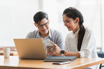 Asian business people man and woman conference talking and working with laptop together. Young couple work at home.