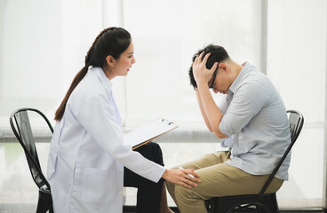Young beautiful asian woman psychologist doctor consulting to male patients lay down on sofa in therapy session.