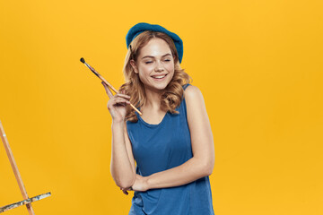Artist woman in blue beret brush easel art drawing education hobby Creative approach yellow background
