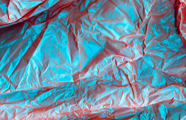 Creased abstract background. Wrinkled paper texture. Glossy blue red distressed surface.