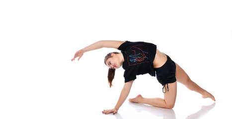 Flexible sports girl performs dance elements on a white background in the studio.