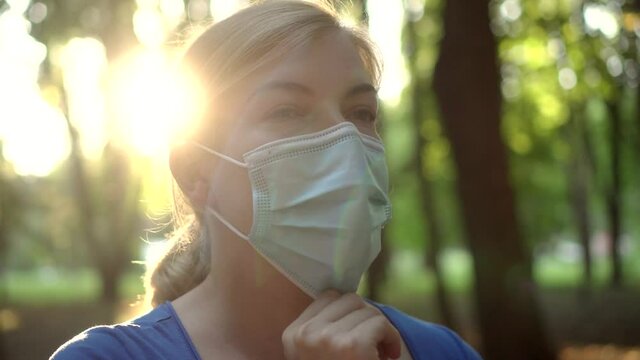 A woman wears a medical mask in a Park