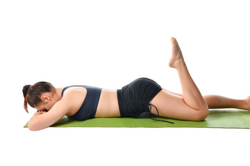 Fototapeta na wymiar Athletic girl lies on a sports mat face down and meditates after yoga exercises.
