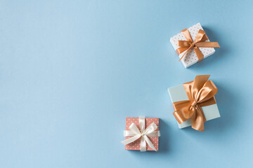 Fototapeta na wymiar Gift boxes with ribbon flat lay on blue pastel background