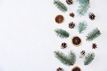 Fototapeta na wymiar Christmas composition with copy space. Decoration made of fir tree branches, pine cones and dried fruits on a white background
